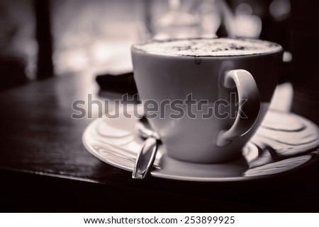 Black white A cup of Cappuccino with retro style coffee shop background memory under light classical
