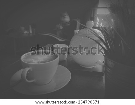 Cup OfCoffee with kettle cafe Interior on table black retro,  Behind have dog looking camera