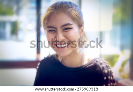 happy woman Asia Smiling white Teeth clean light background teenager gold-brown hair ,make up eye-liner and other ,wearing black T-shirt ,expression so friendly