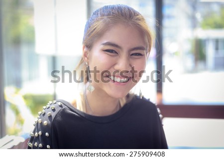 happy woman Asia Smiling white Teeth clean light background teenager gold-brown hair ,make up eye-liner and other ,wearing black T-shirt ,expression so friendly