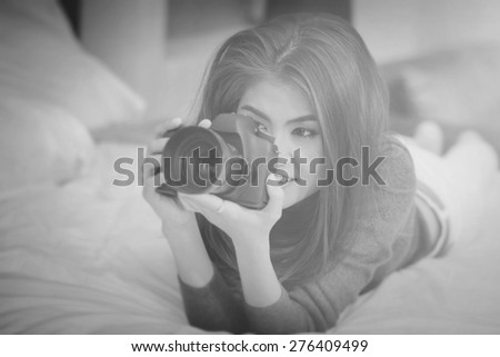 Asian woman hold dslr black camera on white bed look vintage style long gray shirt so lovely girl ,Black and white