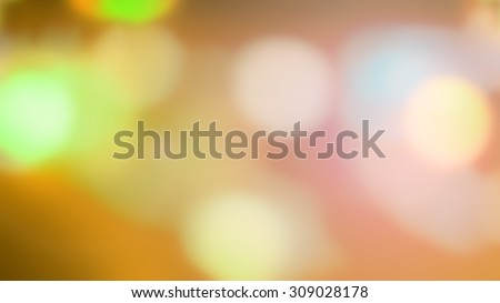 Festive abstract background with circle bokeh defocused green orange yellow blue brown lights.