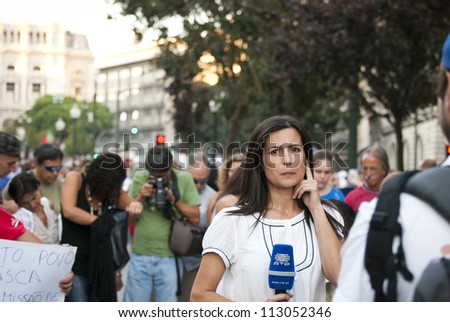 PORTO, PORTUGAL - SEPTEMBER 15: Journalist making report for portuguese national television with protestors against government spending cuts and tax rises in Aliados, Porto on September 15, 2012 in Porto, Portugal