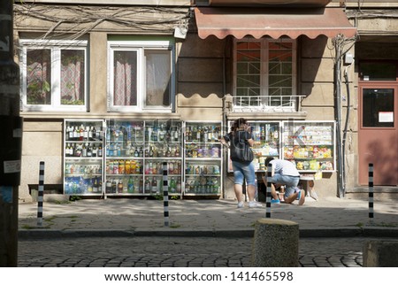 SOFIA, BULGARIA - APRIL 30: People buying groceries in small street shop through the window in Sofia, Bulgaria, on April 30, 2013.