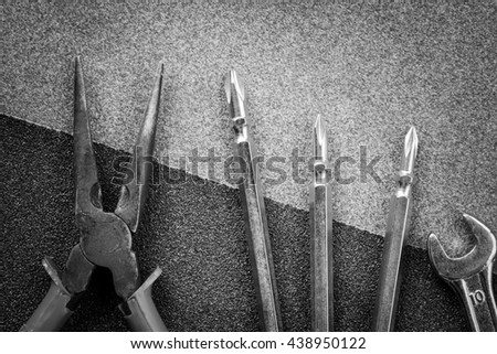 Pliers, Screwdrivers and wrench on sandpaper background - mechanic tools - Black and White