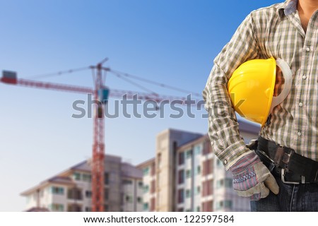 Worker and the blurred construction background in blue sky