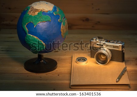 vintage still life with film cameras that had been popular in the past and ancient book near globe handmade
