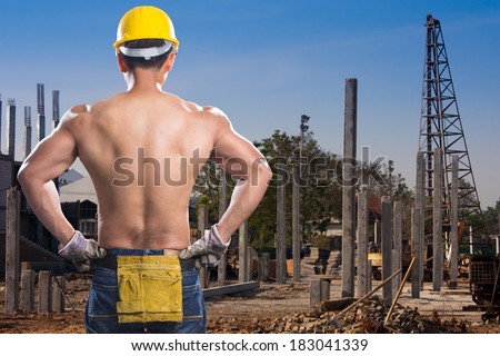 a back view of construction worker showing his muscles with precast concrete piles in a construction area
