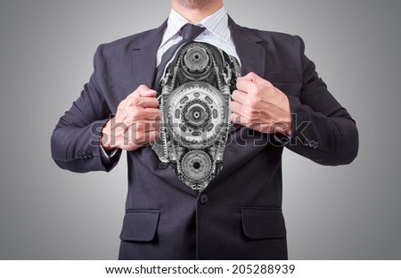businessman acting like a super hero and tearing his shirt off showing a super hero suit underneath his suit body gear and chain made from scrap metal