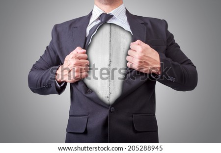 businessman acting like a super hero and tearing his shirt off showing a super hero suit underneath his suit body iron plate made from scrap metal