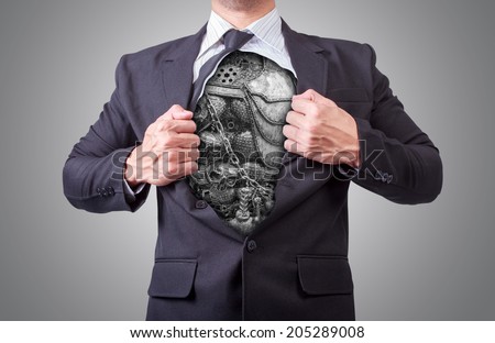 businessman acting like a super hero and tearing his shirt off showing a super hero suit underneath his suit body skull chain armor and made from scrap metal