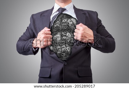 businessman acting like a super hero and tearing his shirt off showing a super hero suit underneath his suit body car parts made from scrap metal