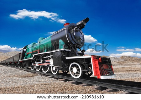 vintage black steam powered railway train against blue sky background