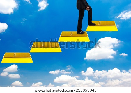 business man walking up gold bars stepping ladder on blue sky  idea concept step by step for success and growth business