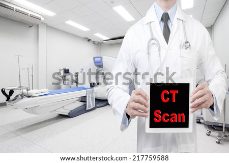 doctor presenting word ct scan digital tablet screen at computed tomography or computed axial tomography scan machine in hospital room