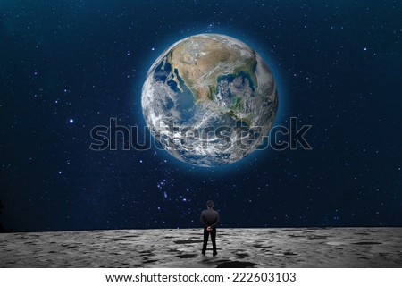 Businessman on the Moon looking at the Earth planet \