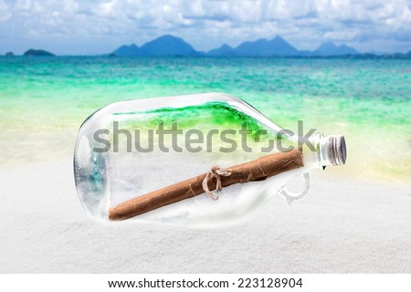 old bottle and roll paper message on sand and tropical sea