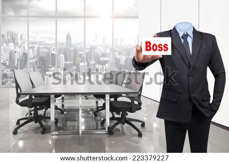 Empty business suit concept for invisible anonymous holding business card word boss at conference room in modern office interior on high building