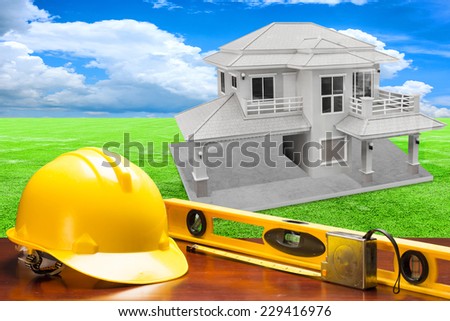 engineer working table and measure tape and level water tool equipment against house structure  in concept of real estate and engineering
