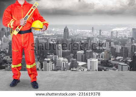 technician in uniform working at high building construction site against urban scene balcony over looking city dusky before rain falling