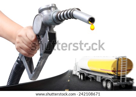 Hand holding a classic fuel nozzle pumping and truck with fuel tank in motion blur on the highway
