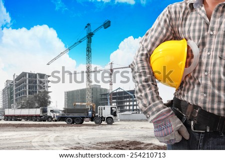 civil engineer half body working in building construction site with tower crane and blue sky