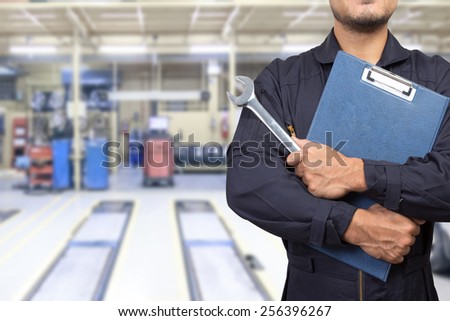mechanic holding a clipboard of service order with wrench at the repair shop