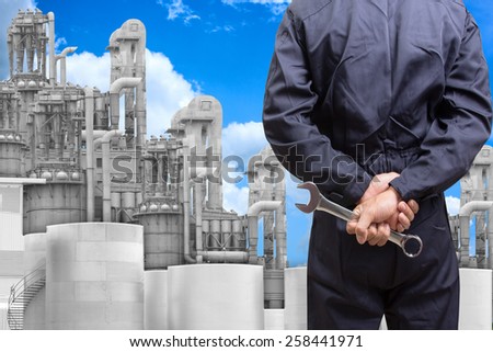 mechanic holding tools for maintaining at petrochemical Industrial plant with blue sky