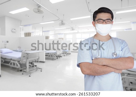 surgeon pose arms crossed behind back in aided the recovery room with modern equipment and comfortable equipped in hospital