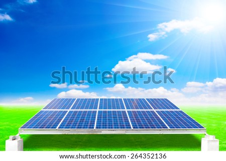 Solar energy panels on green grass field against beautiful sky