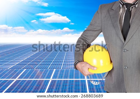 business man holding helmet for working at solar energy power plant against beautiful sky with in concept ecology