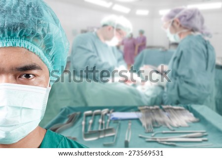 Surgeon looking at camera with equipment tools for surgeons who need to operate a patient in an operation room arranged on a table for a surgery of surgeon in operating room