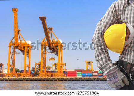 dock worker holding helmet for working at harbor