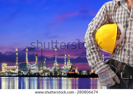 Worker working at oil refinery petrochemical industrial plant at twilight