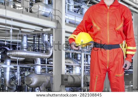 Engineer holding hard hat in action for working with equipments and machinery in a modern thermal power plant