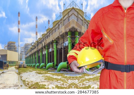 Technician holding hard hat for working at cooling tower of Industrial power plant