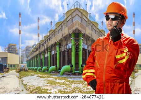 Engineer with radio communication in action for working at cooling tower of Industrial power plant