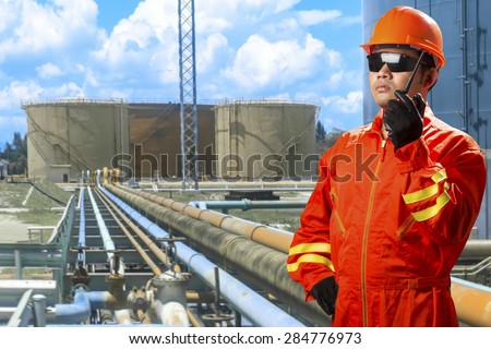 Engineer with radio communication for working at pipe line connection to oil tanks in petrochemical oil refinery