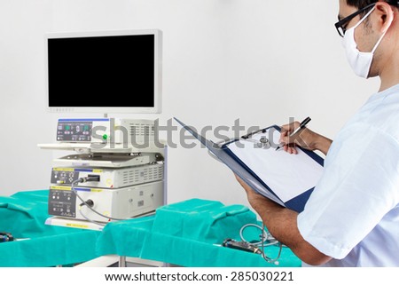 Doctor record clipboard and equipment tools in operating room