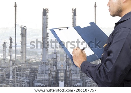 Engineer recording maintenance report for working at oil refinery petrochemical industrial plant