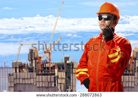 Civil engineer use radio communication control working at high building construction site