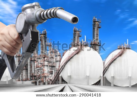 Hand holding a fuel nozzle for direct sale to consumer at petrochemical oil refinery