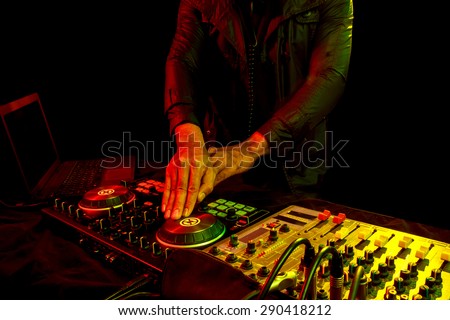 Disc jockey mixes dance song in nightclub at party