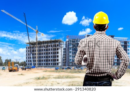 Foreman holding blueprint and the blurred construction site