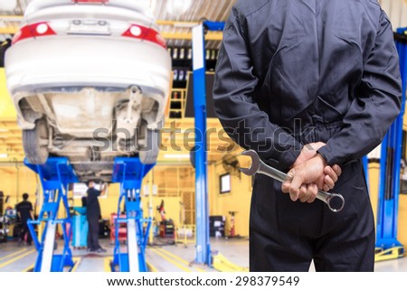 Mechanic holding tools of service order for maintaining car at the repair shop