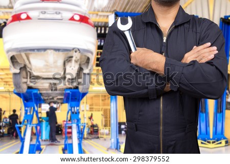 Mechanic working and holding wrench of service order for maintaining car at the repair shop