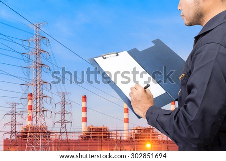 Engineer maintenance recording on clipboard at Industrial power plant