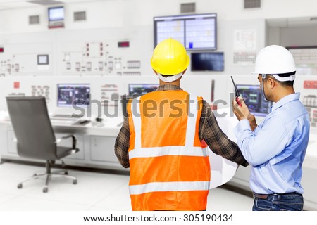 Engineer and foreman use radio communication for command working at control room of a modern thermal power plant
