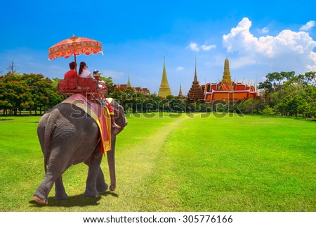 Elephant and tourists on an ride tour at the Buddhist temple of Wat Phra Kaeo at the Grand Palace in Bangkok,Thailand