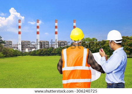 Engineer and foreman use radio communication for command working at modern thermal power plants and electric high voltage towers with green park ecology